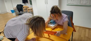 Zwei Therapeutinnen üben mit Kleiderbügeln